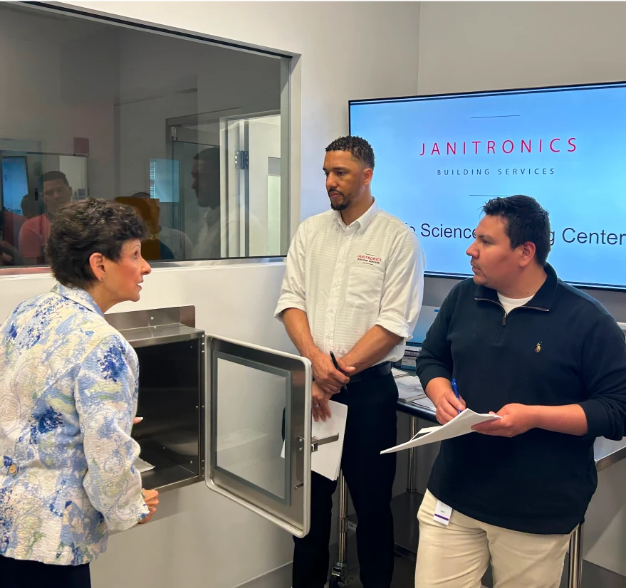 Business professionals discussing laboratory cleaning protocols in a modern training facility