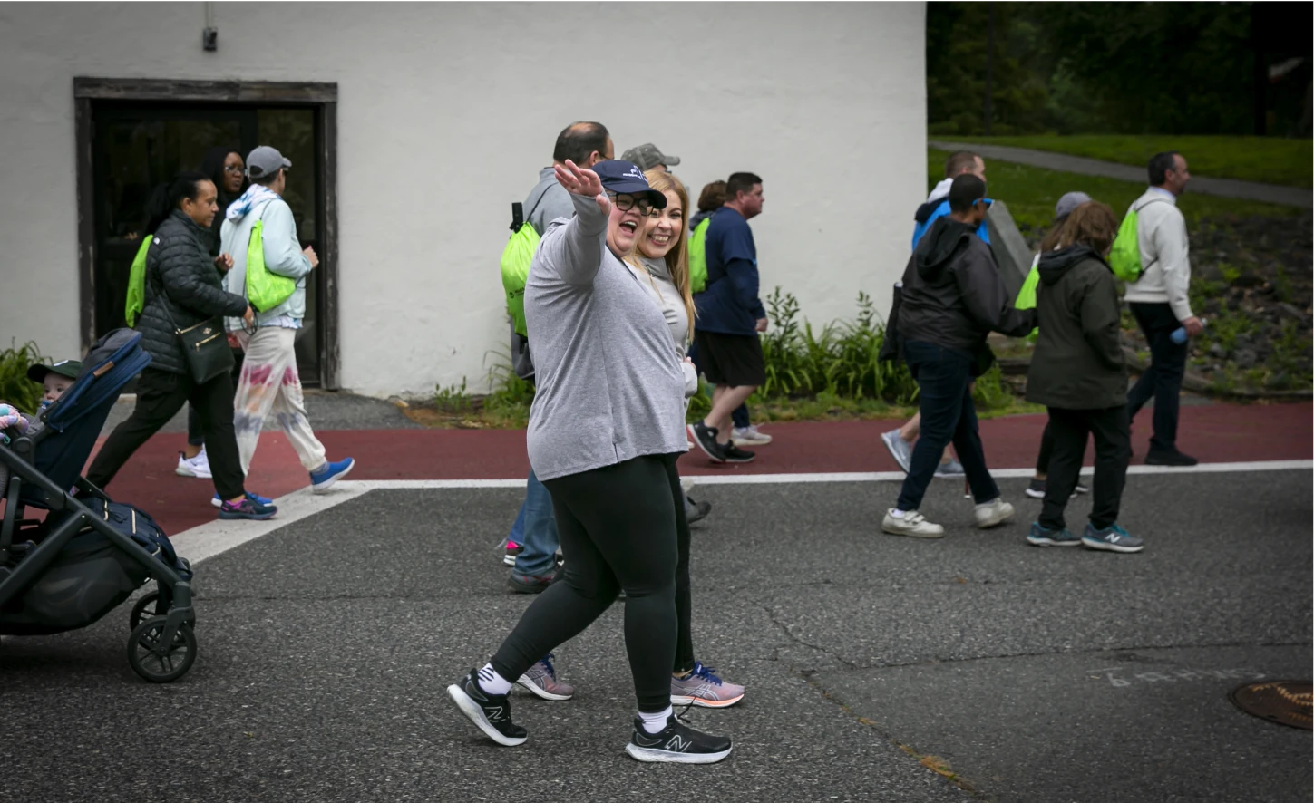 Group of people, some wearing bright backpacks, walk together in a public event