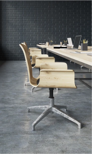 Modern office conference room with wooden chairs and a long table against a black brick wall