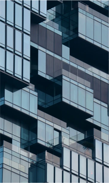 Close-up of a modern glass building with unique geometric balconies and reflective windows