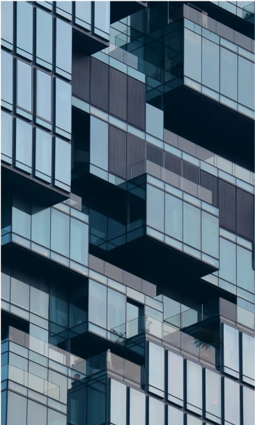 Unique modern glass building with staggered balconies and reflective windows