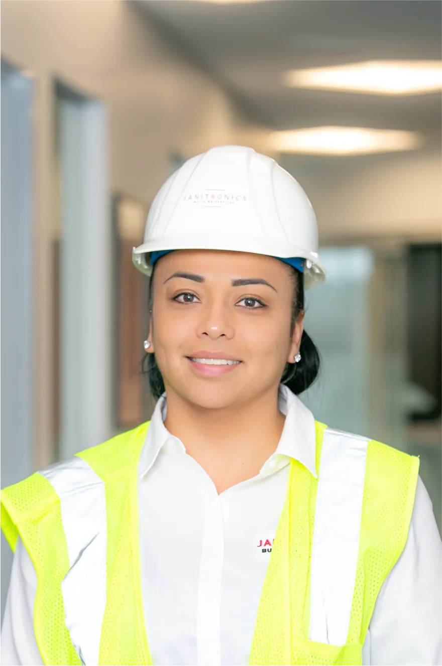 Female safety officer in high-visibility gear standing in a well-lit hallway