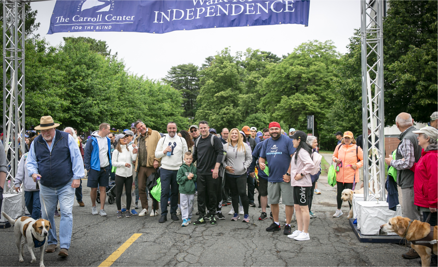 Excited crowd at the starting line of a Walk for Independence event with greenery in the background
